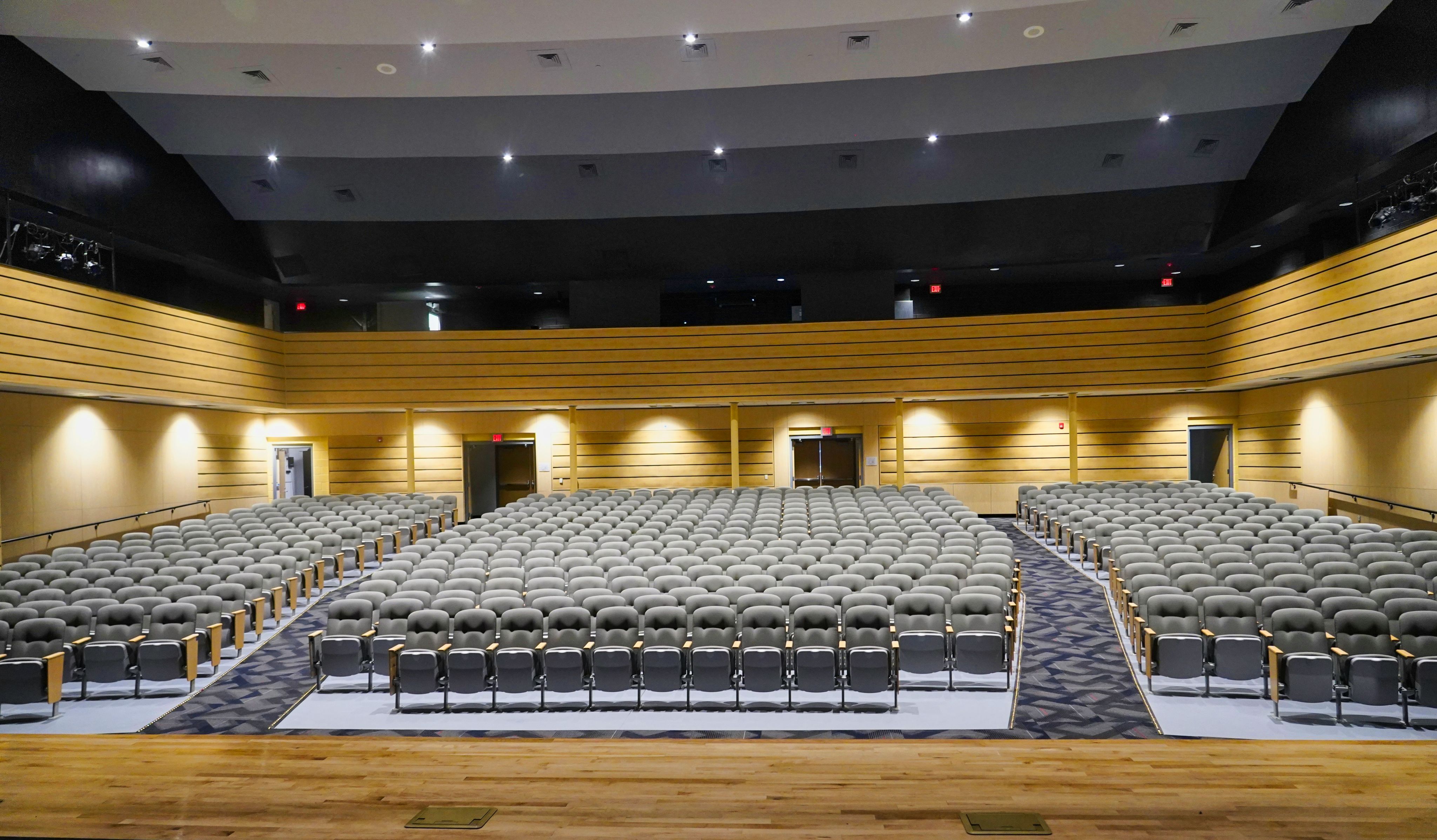 a large auditorium with rows of chairs and a podium